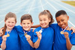 © Monkey Business - Portrait Of Children Showing Off Winners Medals On Sports Day