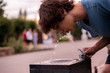young man feel thirsty,  drinking water from public city fountain