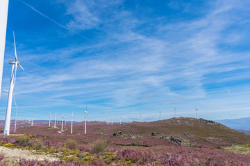 wind turbines over mountains and blue sky