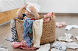© Lisa Tichané - Funny baby sitting in laundry basket with clothes on head