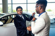 © yurakrasil - african-american salesman hand shake with indian buying customer at auto showroom