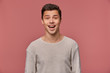 © timtimphoto - Portrait of cheerful handsome young guy wears in blank long sleeve, looks at the camera with happy expression, stands over pink background.