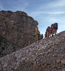 Wall Mural - some hikers go up a steep rocky mountain path.