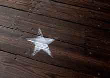A Faded White Start Painted Onto A Wooden Plank Floor