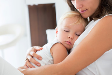 Canvas Print - Young mother lying in bed with her sleeping toddler baby boy