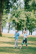 © LIGHTFIELD STUDIOS - cheerful mature man and woman walking together in park while holding yoga mats