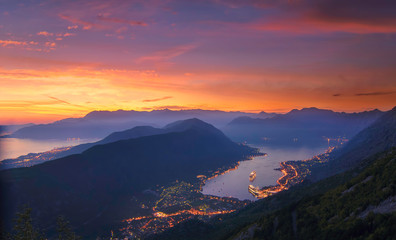 Kotor bay seen from above in a beautiful sunset summer day. Monenegro, View above houses, streets and port of kotor bay city with huge cruise ship anchoring by night