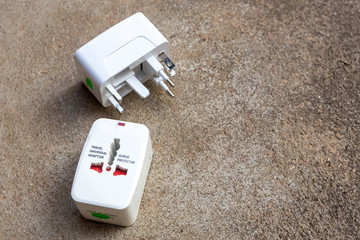 Close up of universal electric socket plug adapters used for travel. Used to connect to different electrical outlets worldwide. Electric adapter isolated on dark background.