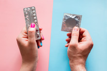 Woman Holds Birth Control Pills, Man Holds Condom