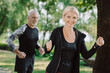 © LIGHTFIELD STUDIOS - cheerful mature sportsman and sportswoman jogging in park together