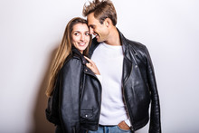 Young Beautiful Couple In Black Leather Jackets Pose In Studio.