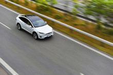 Modern Electric Crossover Car Is Driving By Highway On High Speed