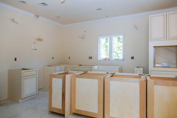 Wall Mural - Custom kitchen cabinets in various stages of installation base for island in center