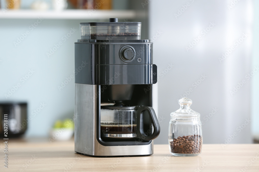 Modern coffee machine on table in kitchen
