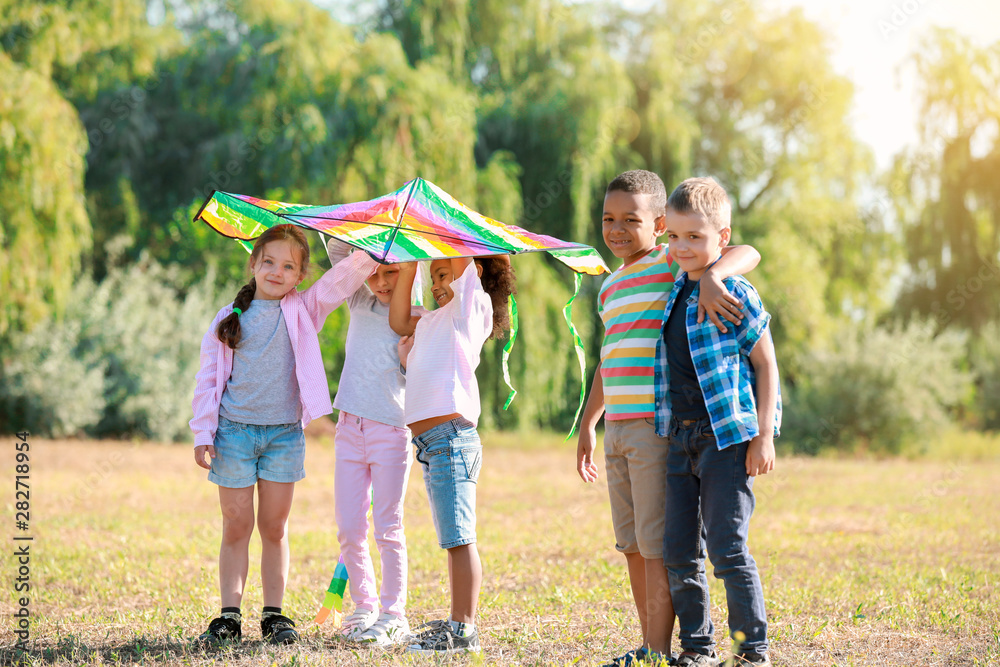 Group of happy children with kite in park