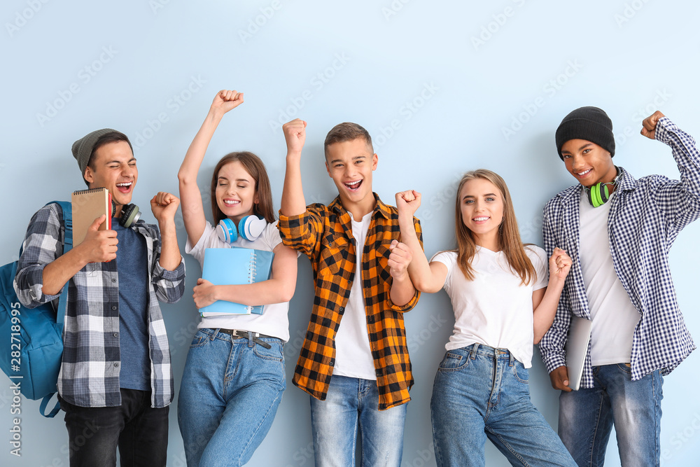 Portrait of happy young students on color background - obrazy, fototapety, plakaty 