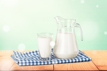 Wall Mural - A glass of milk and a milk jug on plaid tablecloth