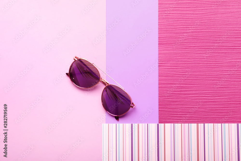 Stylish sunglasses on color background