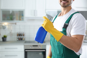 Wall Mural - Janitor with sprayer in kitchen, closeup. Cleaning service