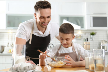 Canvas Print - Dad and son cooking together in kitchen