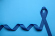 © New Africa - Blue awareness ribbon on color background, top view with space for text. Symbol of social and medical issues
