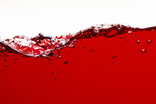 Red Bright Liquid With Splash And Bubbles Isolated On White