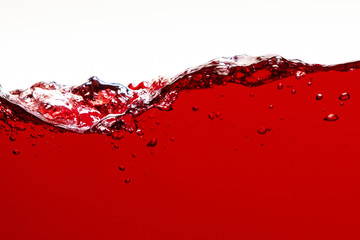 red bright liquid with splash and bubbles isolated on white