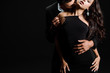 cropped view of passionate man kissing woman in dress isolated on black