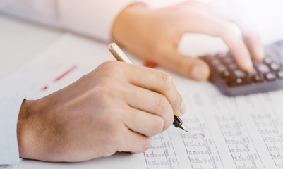 Poster - Businessman using a calculator to calculate the numbers