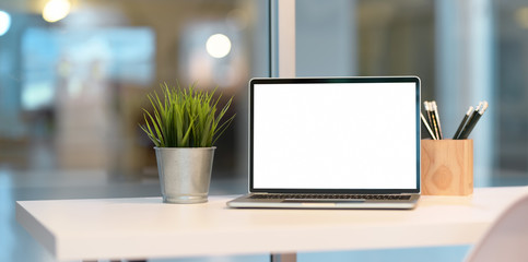 Open blank screen laptop with office supplies