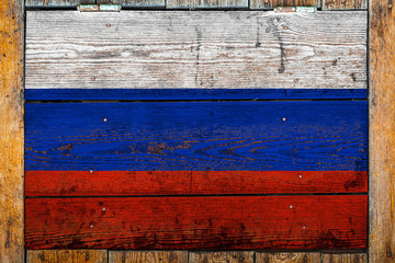 National flag of Russia on a wooden wall background.The concept of national pride and symbol of the country.Flag painted on a wooden fence with metal nails.