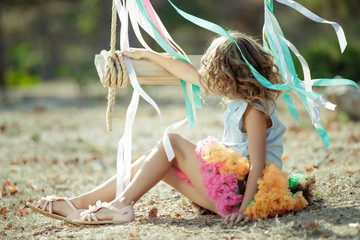 Little girl riding on a swing. 