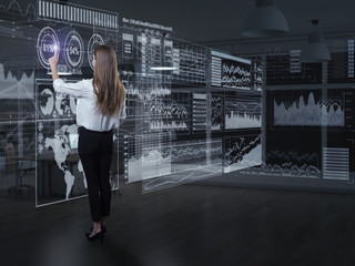 Wall Mural - back view of businesswoman working with virtual panel