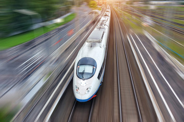 Railroad travel high speed fast train passenger locomotive motion blur effect in the city, top aerial view from above.