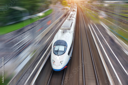 Cuadros en Lienzo Railroad travel high speed fast train passenger locomotive motion blur effect in the city, top aerial view from above