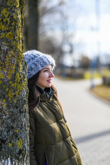 Girl in a warm knitted hat. Portrait of a beautiful young model in a gray knitted hat. walking down the street