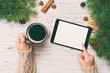© sosiukin - Christmas online shopping. Female hand touch screen of tablet, top view on wooden bakground, copy space and holding mug of coffee. Winter holidays sales background. Toned