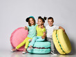 © FAB.1 - Three friends of triplets - two girls and a boy in bright clothes have fun at the birthday party fun room decoration candy macarons