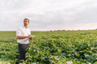 © Serhii - Portrait of young farmer standing in soybean field.