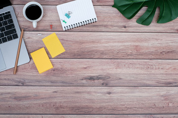 Wall Mural - Work space brown wooden office desk table with laptop computer and coffee cup, leaves and supplies, Flat lay, Top view with copy space