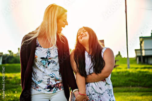Fotomural A Portrait of trisomie 21 adult girl smilin outside at sunset with family friend