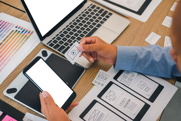 user experience UX designer designing web on smart phone layout. UI developer planning working on mobile application prototype