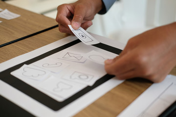 user experience UX designer designing web on smart phone layout. UI developer planning working on mobile application prototype