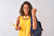Brazilian student woman wearing backpack holding notebook over isolated white background annoyed and frustrated shouting with anger, crazy and yelling with raised hand, anger concept
