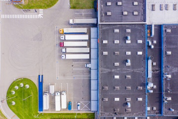 Aerial view of warehouse storages or industrial factory or logistics center from above. Aerial view of industrial buildings and equipment machines at sunset, toned