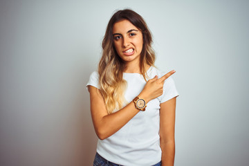 Young beautiful woman wearing casual white t-shirt over isolated background Pointing aside worried and nervous with forefinger, concerned and surprised expression