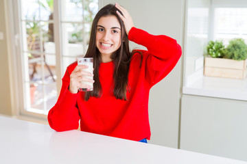 Poster - Beautiful young woman drinking a glass of fresh milk stressed with hand on head, shocked with shame and surprise face, angry and frustrated. Fear and upset for mistake.