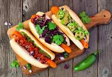 Carrot Hot Dogs With Assorted Toppings. Top View On Paddle Board With A Rustic Wood Background. Plant Based Vegan Meal Concept.