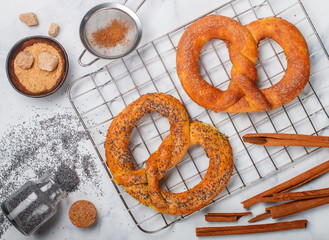 Wall Mural - Pretzel. Freshly baked pretzels with sugar, poppy seeds and cinnamon. Delicious homemade cakes and ingredients on the table. Selective focus, top view