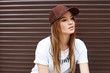 © yuliachupina - Beautiful blonde girl in a brown cap on a wall background